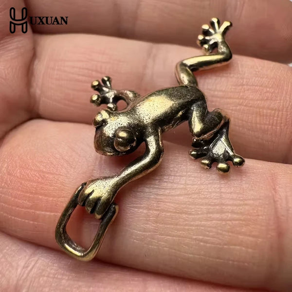 Vintage brass frog statue desktop ornament resting on a person's hand