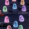 A collection of luminous ghost mini figurines in various pastel colors including pink, purple, green, and yellow.