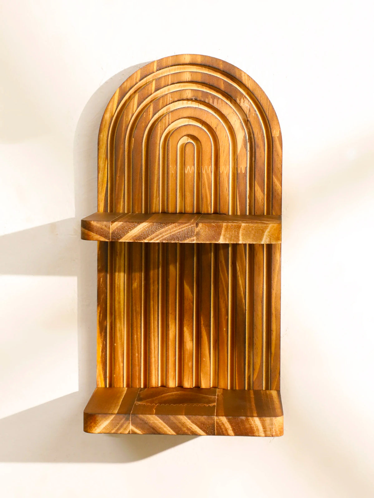A vertical wooden wall shelf with a curved, ribbed design and a horizontal shelf.