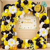 A yellow, black, and white balloon arch set decorated with bees and daisies for a birthday celebration.