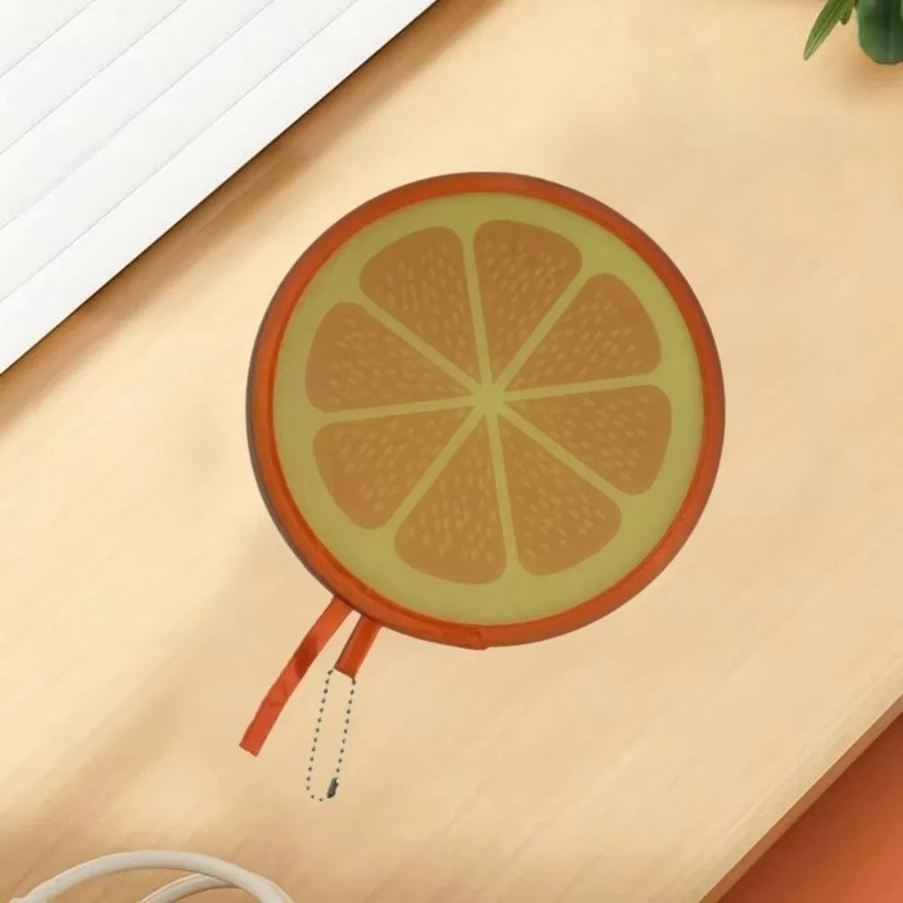 A round fruit design, resembling an orange slice, is shown on a light wooden surface.