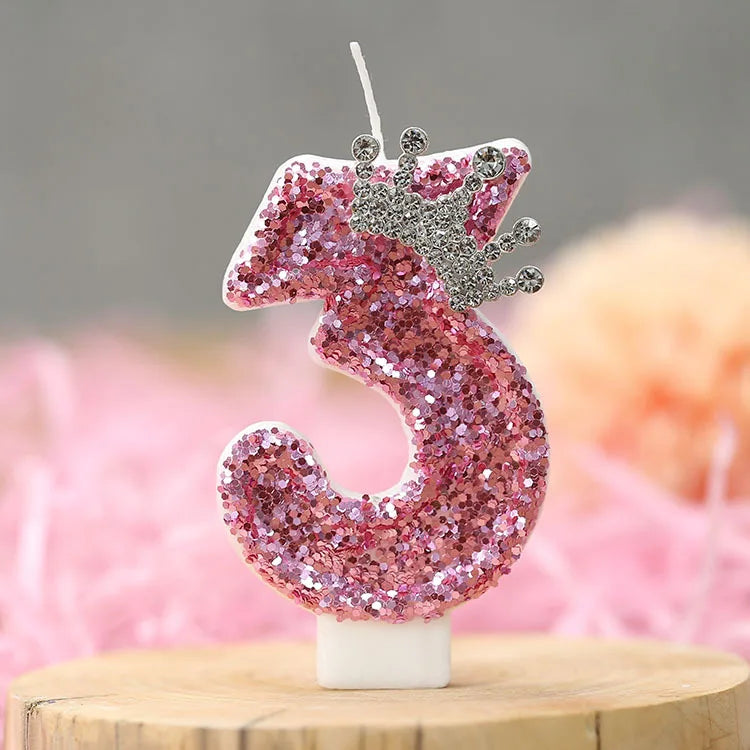 Pink glitter birthday number three candle with a silver crown topper
