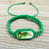 A green braided bracelet with a carved wooden oval depicting the Virgin Mary.