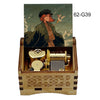 A wooden music box with a lid featuring an illustration of a woman and a bird, set within a wooden box.