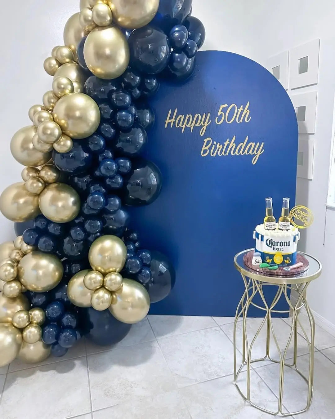 A balloon arch featuring metallic gold and navy blue balloons for a 50th birthday celebration.