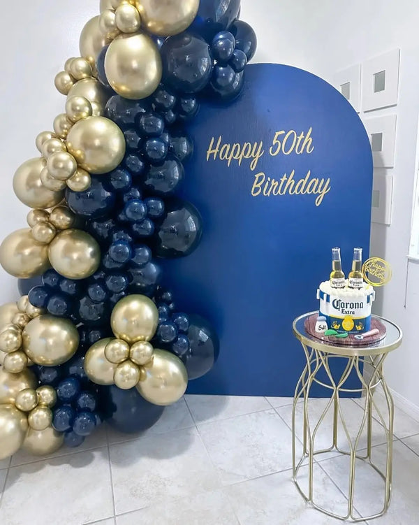 A balloon arch featuring metallic gold and navy blue balloons for a 50th birthday celebration.