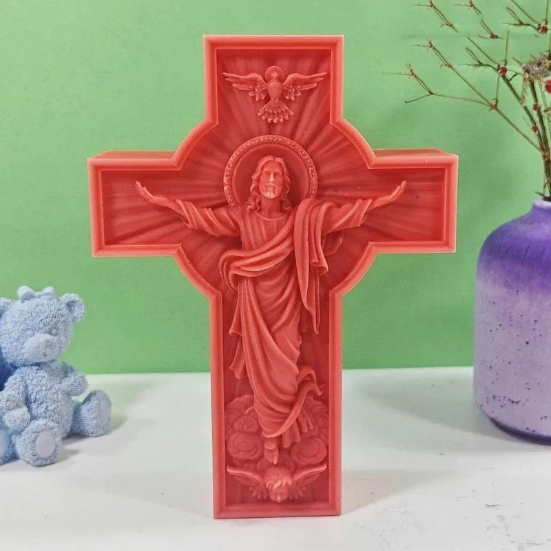 A red silicone mold of a crucifix featuring Jesus with a halo and outstretched arms.