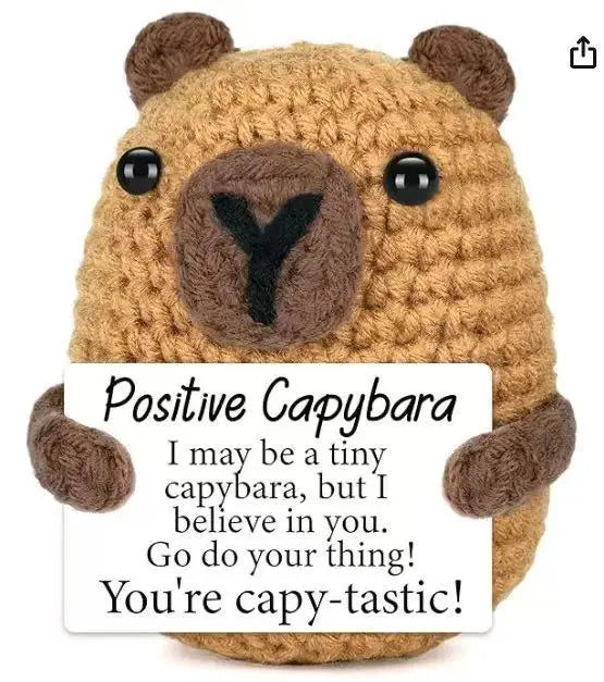 Handmade crochet baseball bat doll with a positivity card featuring a capybara face.