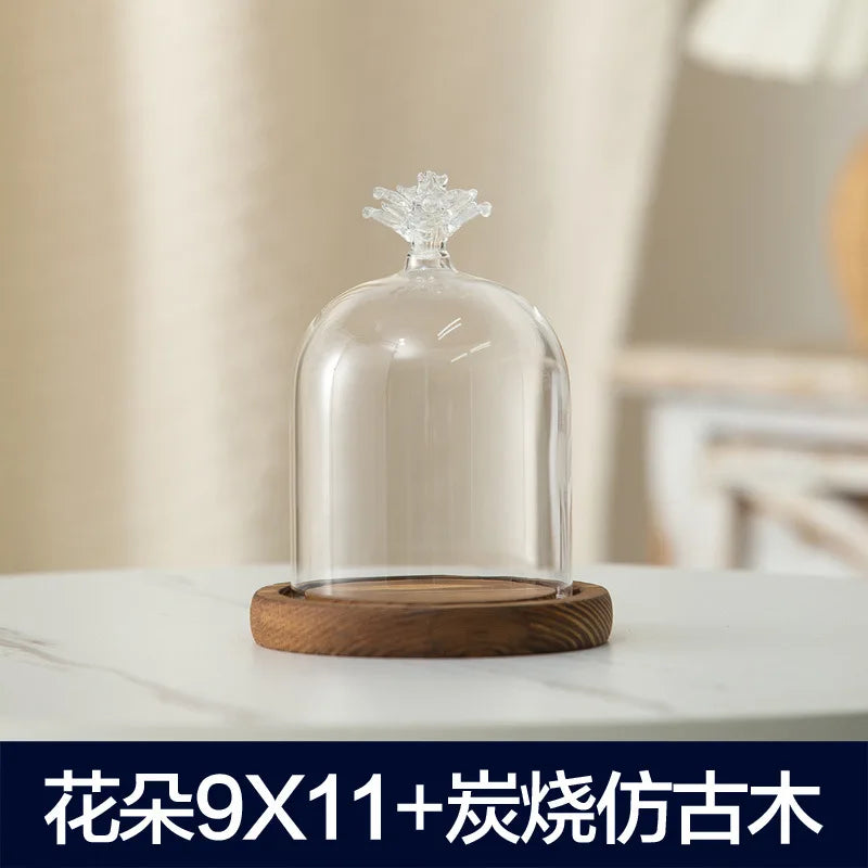 Clear glass aromatherapy candle holder with a decorative top and a wooden base.