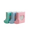 A set of four pastel pink and blue heart-shaped photo albums with clear covers and zippers.