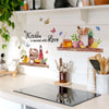 A floral wall sticker featuring bees and butterflies is displayed on a white shelf above a kitchen countertop.