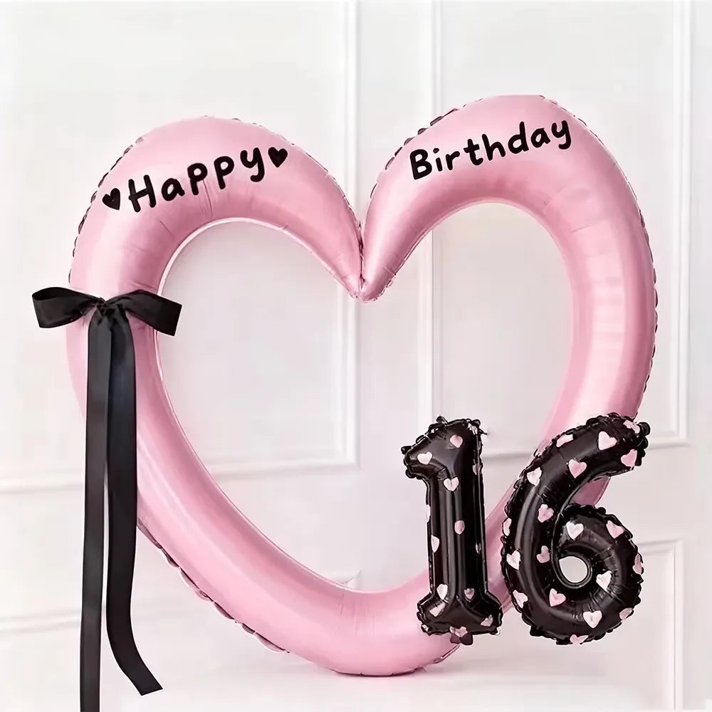 Pink heart-shaped balloon decoration with black text Happy Birthday and the number 16