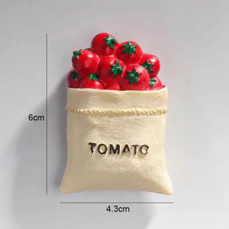 A small beige pouch filled with red tomato fridge magnets and a gold tomato label.