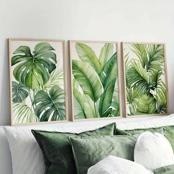 A set of three framed watercolor prints featuring lush green tropical leaves on a white background.