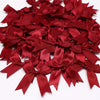 A pile of elegant red satin ribbon bows for gift wrapping and decor.