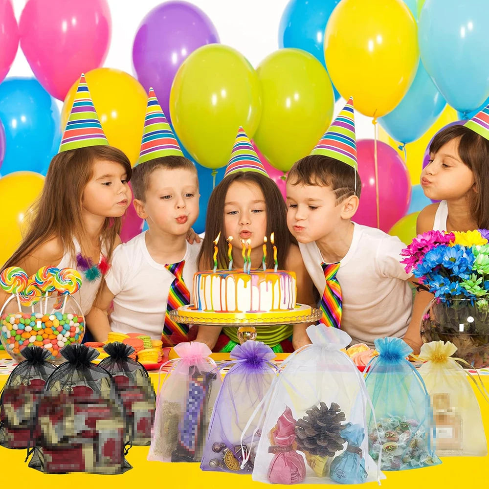 Elegant white and gold drawstring organza bags for gifts, weddings, and parties displayed with balloons and candles