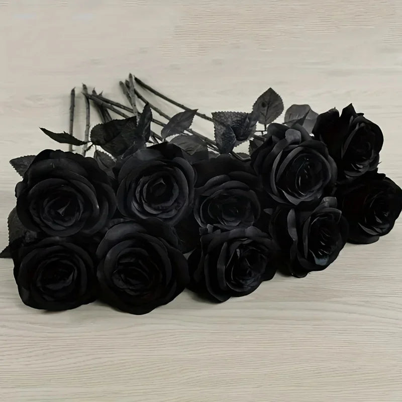 A dark arrangement of artificial black roses and leaves for home decor.