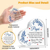 A hand holds a clear acrylic heart plaque with decorative script on it, demonstrating the product size.