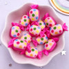 A pink dish filled with colorful candy resin cabochons in various shades of pink and yellow.