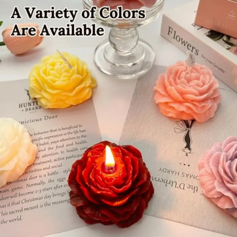 A variety of colorful handcrafted rose-shaped scented candles are displayed on a white surface.