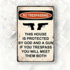 Rustic metal wall art sign with 'No Trespassing' text and silhouettes of guns.