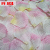 Pink and white silk rose petals scattered on a surface for weddings and events