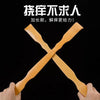 A pair of wooden bamboo back scratchers crossed in an X shape, held by a hand against a black background.