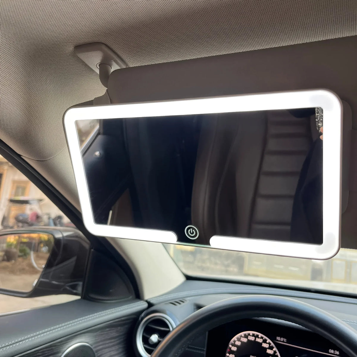 Interior view of a car showing a mounted vanity mirror with an LED light.