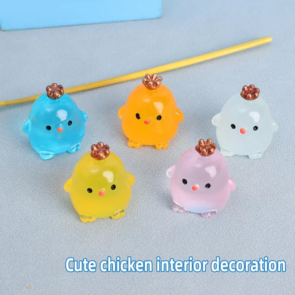 A collection of colorful luminous resin chicken ornaments in shades of blue, orange, yellow, and pink.