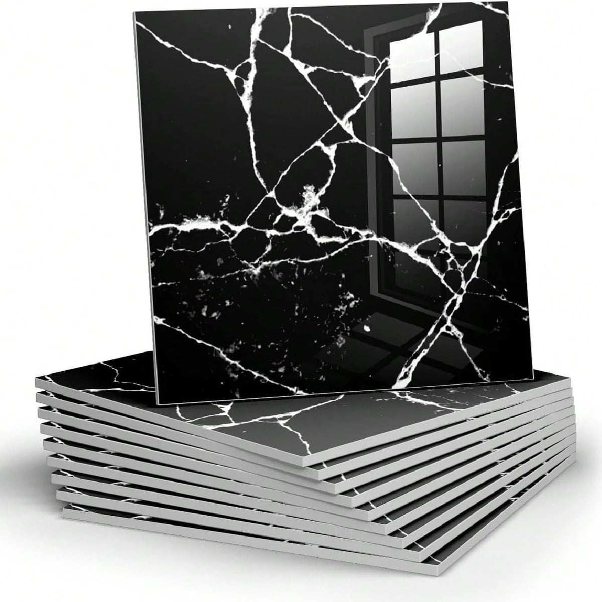 A black marble peel-and-stick wall panel with white veining is displayed on a stack of similar panels.