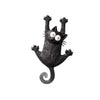 Schwarze Keramikfigur einer Katze mit großen Augen und markanten Schnurrhaaren.