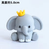 A gray elephant figurine with a yellow crown, used for birthday decorations.