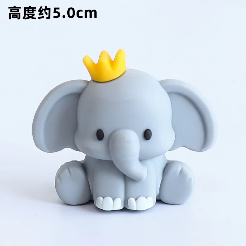 A gray elephant figurine with a yellow crown, used for birthday decorations.