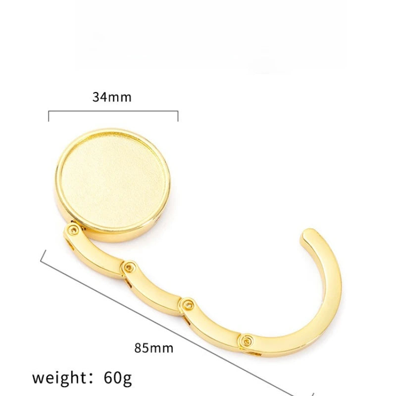 A gold-colored compact folding table bag hook with a 34mm opening and an 85mm length.