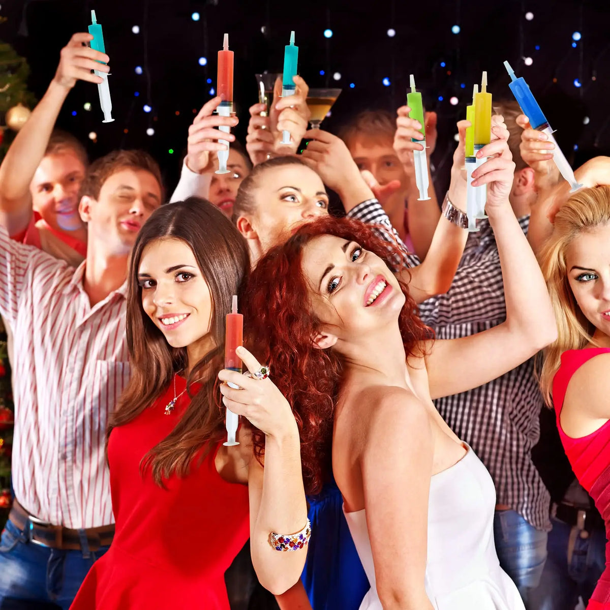 A group of people raising party syringes in a celebratory atmosphere.