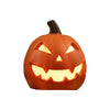Linterna de calabaza de cerámica naranja tallada con una cara sonriente y amenazadora para decoración de Halloween.