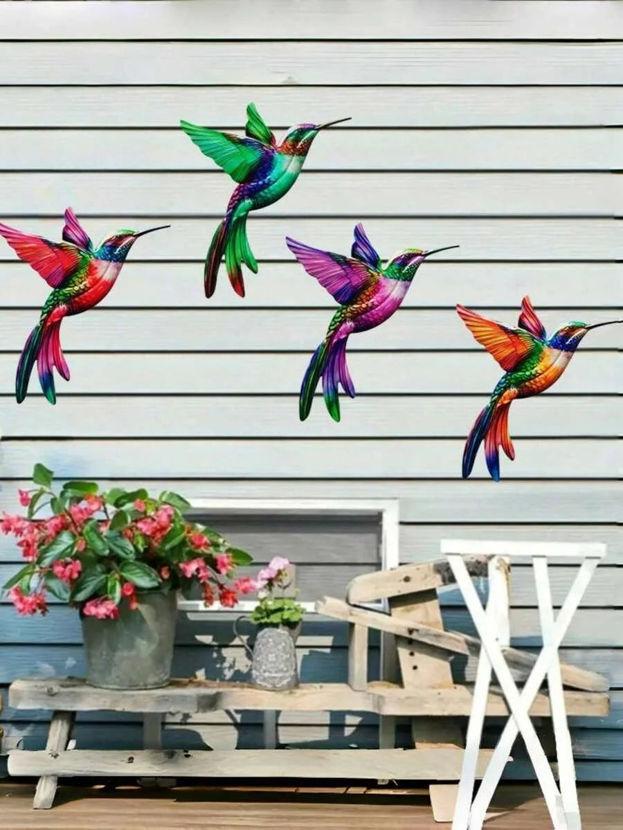 Four iridescent metal hummingbird wall decor birds in vibrant colors perched on a wooden surface.
