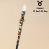 A natural clear quartz zodiac crystal wand featuring a gold-colored animal charm and an orange bead.
