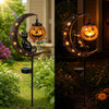 A solar Halloween moon lantern featuring a black cat silhouette and carved pumpkin design in a garden setting.