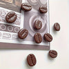 Un set de huit aimants de réfrigérateur en chocolat noir réalistes, présentés sur un fond gris.