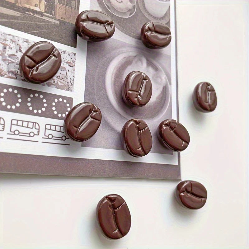 Un set de huit aimants de réfrigérateur en chocolat noir réalistes, présentés sur un fond gris.