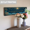 A rectangular dark blue metal tin sign featuring celestial designs and text, displayed on a wooden surface.
