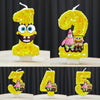 A set of SpongeBob character birthday candles shaped like the numbers 0 through 9, made of yellow glitter cake.