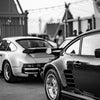Une voiture noire et moderne est garée à l'extérieur, vue de profil.