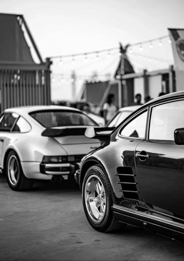 Une voiture noire et moderne est garée à l'extérieur, vue de profil.
