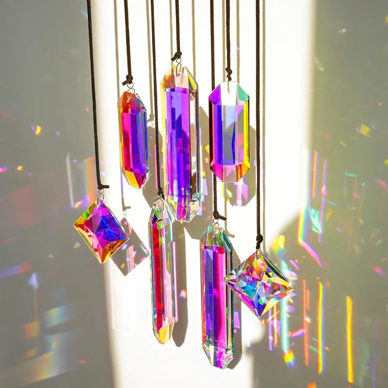 A set of seven iridescent crystal prism sun catchers hanging by thin black strings.