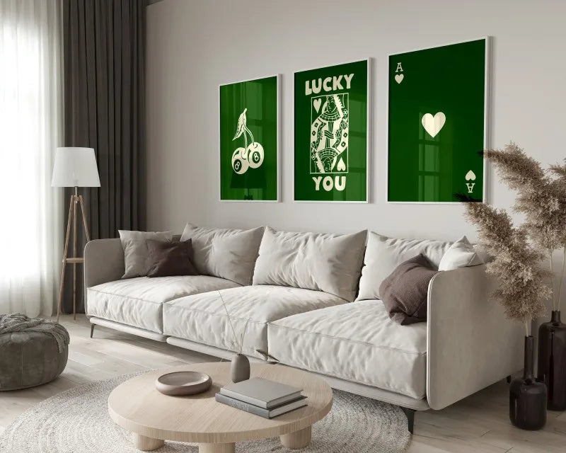 A modern living room features a light sofa and green framed art prints with gold lettering on a white wall.
