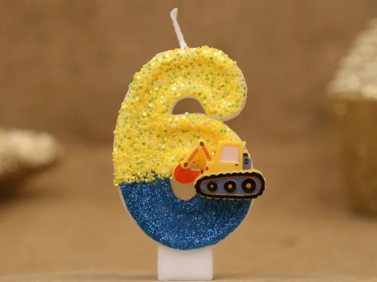 A birthday candle shaped like the number 6, decorated with yellow glitter and a construction excavator face on a blue base.