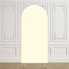 Un arco de tela de color crema y alto, exhibido contra una pared de paneles blancos.