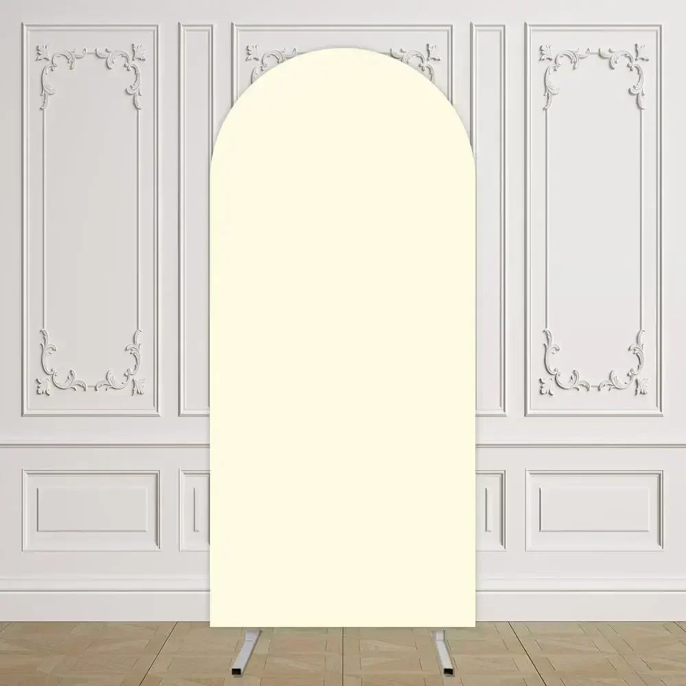 Un arco de tela de color crema y alto, exhibido contra una pared de paneles blancos.